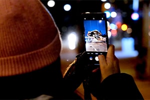 woman using samsung s22 to take a picture at night