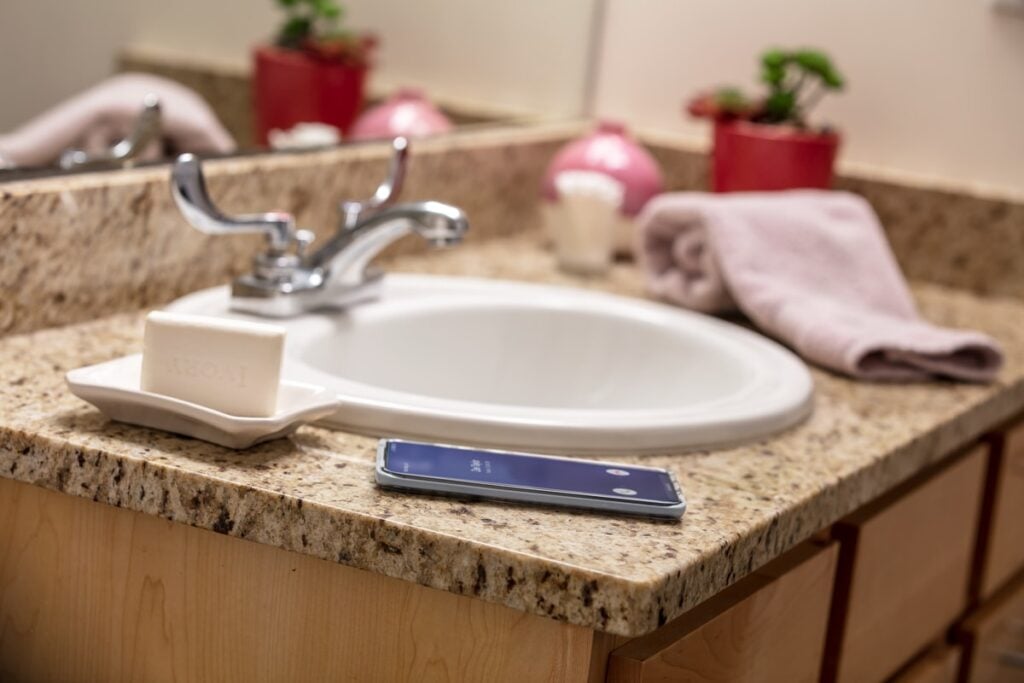 iphone sitting on bathroom sink 