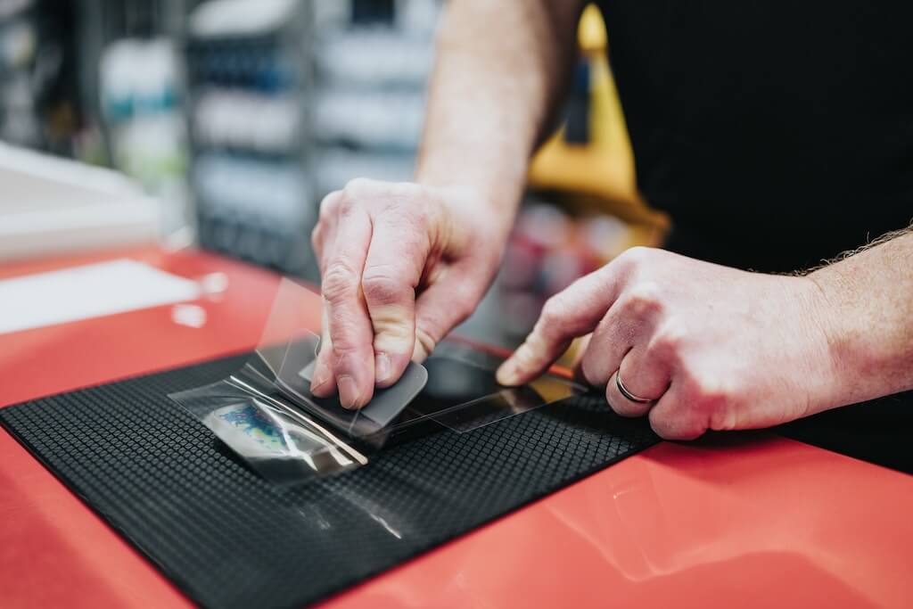 Worker installing a screen protector