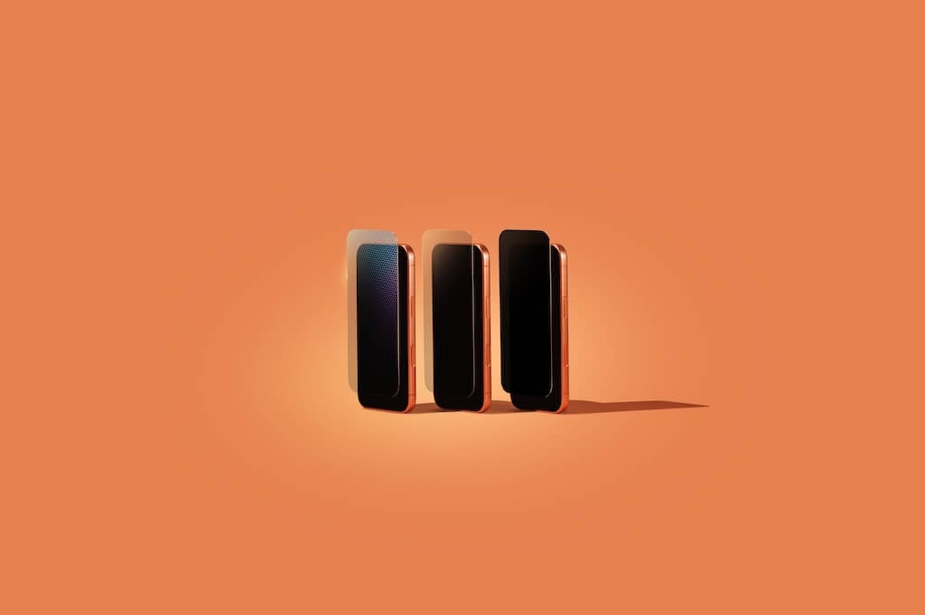 Three phones with three different screen protectors standing up