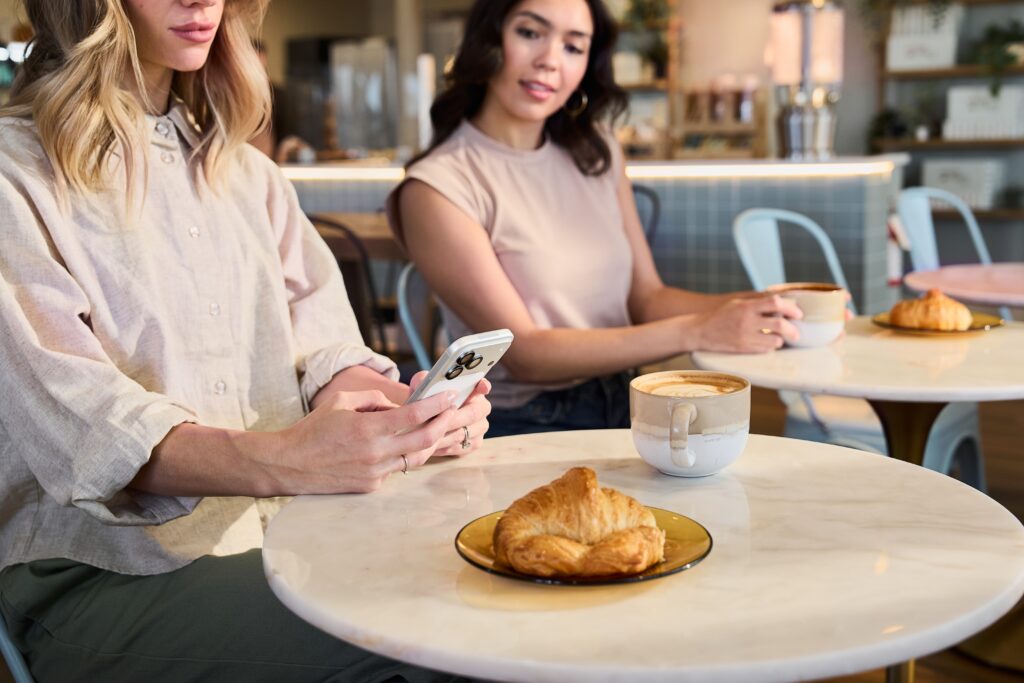 woman sitting in cafe on phone 